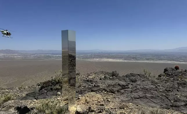 This photo provided by Las Vegas Metropolitan Police Department, the mysterious Monolith is removed on Thursday, June 20, 2024 in Gass Peak, part of the vast Desert National Wildlife Refuge in Nevada. A strange monolith found jutting out of the rocks in a remote mountain range near Las Vegas has been taken down by authorities. (Las Vegas Metropolitan Police Department via AP)