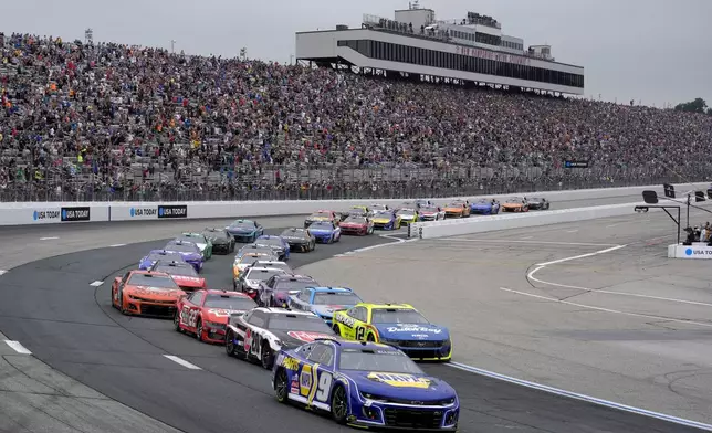 Chase Elliott (9) steers his car while leading a tight pack as they enter Turn 2 during a NASCAR Cup Series race, Sunday, June 23, 2024, at New Hampshire Motor Speedway, in Loudon, N.H. (AP Photo/Steven Senne)