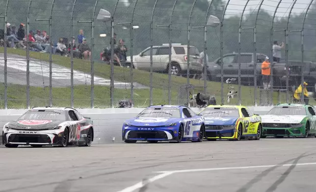 Drivers steer their cars along the back straight, from left, Christopher Bell (20), Tyler Reddick (45), Ryan Blaney (12), and Todd Gilliland (38) during a NASCAR Cup Series race, Sunday, June 23, 2024, at New Hampshire Motor Speedway in Loudon, N.H. (AP Photo/Steven Senne)