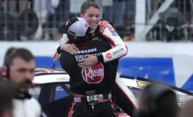 Christopher Bell, top, celebrates with a crew members as he steps out of his car after winning the NASCAR Cup Series race at New Hampshire Motor Speedway, Sunday, June 23, 2024, in Loudon, N.H. (AP Photo/Steven Senne)