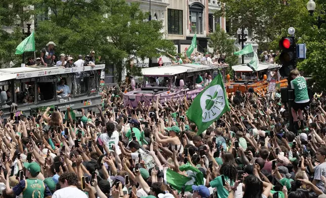 The Boston Celtics celebrate their NBA basketball championship win with a duck boat parade Friday, June 21, 2024, in Boston. (AP Photo/Michael Dwyer)