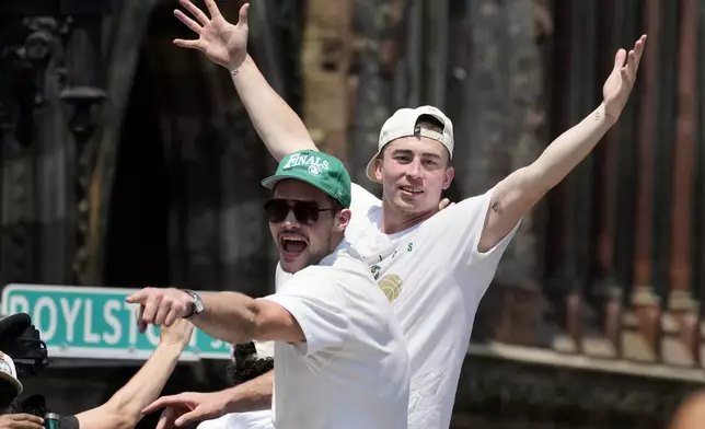 Boston Celtics' Payton Pritchard, right, celebrates the team's NBA basketball championship during a duck boat parade Friday, June 21, 2024, in Boston. (AP Photo/Michael Dwyer)