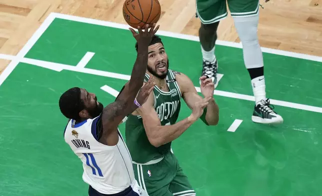 Dallas Mavericks guard Kyrie Irving (11) and Boston Celtics forward Jayson Tatum, right, vie for control of the ball during the first half of Game 5 of the NBA basketball finals, Monday, June 17, 2024, in Boston. (AP Photo/Michael Dwyer)