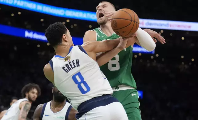 Boston Celtics center Kristaps Porzingis, right, is fouled by Dallas Mavericks guard Josh Green (8) during the first half of Game 5 of the NBA basketball finals, Monday, June 17, 2024, in Boston. (AP Photo/Charles Krupa)