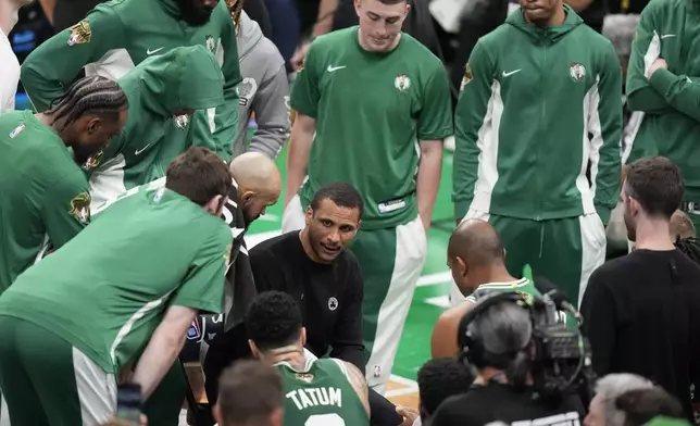 Boston Celtics head coach Joe Mazzulla, center, speaks to his players during a timeout in the first half of Game 5 of the NBA basketball finals against the Dallas Mavericks, Monday, June 17, 2024, in Boston. (AP Photo/Charles Krupa)