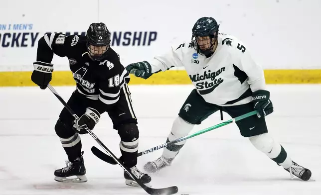 FILE - Western Michigan forward Wyatt Schingoethe (18) is pressured by Michigan State defenseman Artyom Levshunov (5) during the second period of an NCAA college hockey game in Maryland Heights, Mo., March 29, 2024. Levshunov is expected to be selected No. 2 by the Chicago Blackhawks in the upcoming NHL draft. (AP Photo/Colin E. Braley, File)