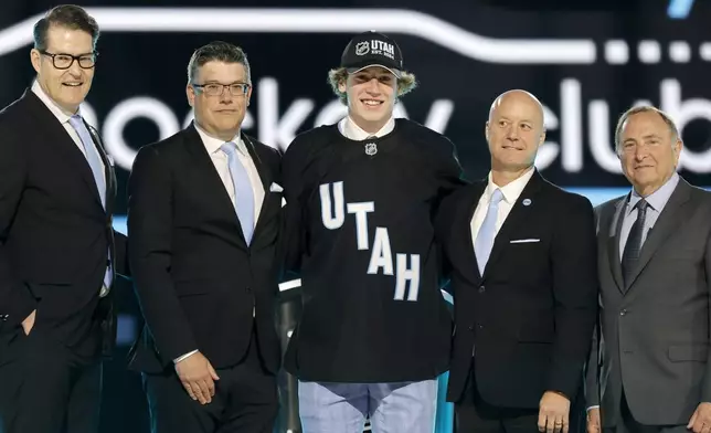 Cole Beaudoin, center, poses after being selected by the Utah Hockey Club during the first round of the NHL hockey draft Friday, June 28, 2024, in Las Vegas. (AP Photo/Steve Marcus)