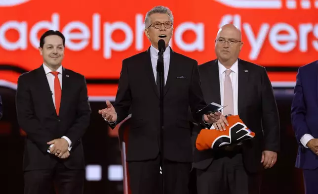 Ring announcer Michael Buffer helps announce the selection of Jett Luchanko by the Philadelphia Flyers during the first round of the NHL hockey draft Friday, June 28, 2024, in Las Vegas. (AP Photo/Steve Marcus)