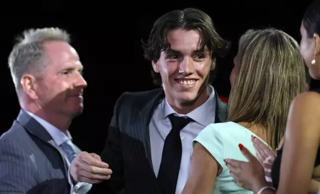 Trevor Connelly, center, is congratulated after being selected by the Vegas Golden Knights during the first round of the NHL hockey draft Friday, June 28, 2024, in Las Vegas. (AP Photo/Steve Marcus)