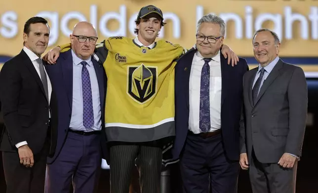 Trevor Connelly, center, poses after being selected by the Vegas Golden Knights during the first round of the NHL hockey draft Friday, June 28, 2024, in Las Vegas. (AP Photo/Steve Marcus)