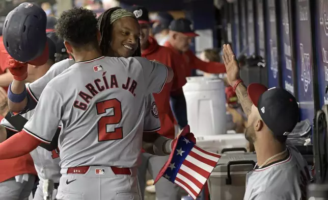 Washington Nationals' Luis Garcia Jr. (2) congratulates CJ Abrams, center, in the dugout after Abrams' solo home run off Tampa Bay Rays starter Aaron Civale during the first inning of a baseball game Saturday, June 29, 2024, in St. Petersburg, Fla. (AP Photo/Steve Nesius)