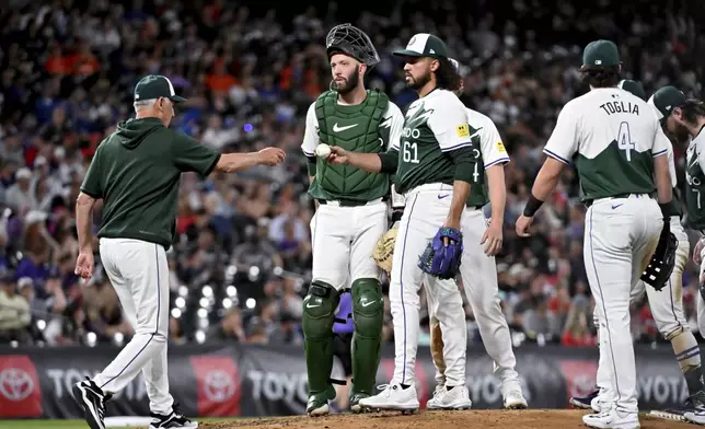 Colorado Rockies manager Bud Black, left, pulls relief pitcher Justin Lawrence (61) during the eighth inning of the team's baseball game against the Washington Nationals on Saturday, June 22, 2024, in Denver. (AP Photo/Geneva Heffernan)
