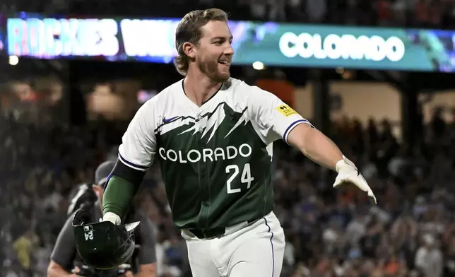 Colorado Rockies' Ryan McMahon celebrates after he was walked with the bases loaded to give the Rockies a win against the Washington Nationals in a baseball game Saturday, June 22, 2024, in Denver. (AP Photo/Geneva Heffernan)