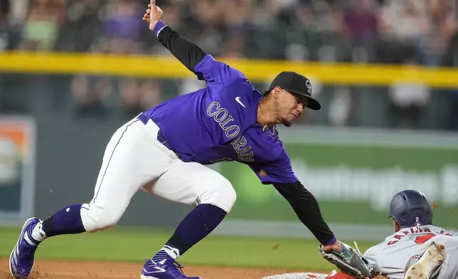 Colorado Rockies shortstop Ezequiel Tovar, left, applies a late tag as Washington Nationals' Luis García Jr. steals second base during the seventh inning of a baseball game Friday, June 21, 2024, in Denver. (AP Photo/David Zalubowski)