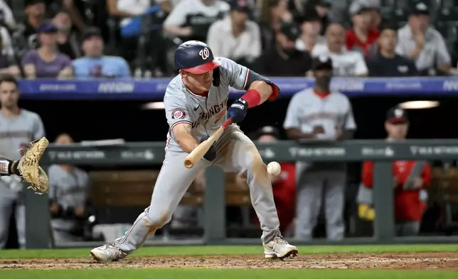 Washington Nationals' Jacob Young singles on a bunt against the Colorado Rockies during the seventh inning of a baseball game Saturday, June 22, 2024, in Denver. (AP Photo/Geneva Heffernan)