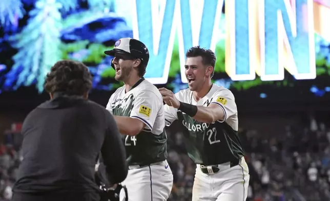 Colorado Rockies' Ryan McMahon (24) and Nolan Jones celebrate the team's win against the Washington Nationals in a baseball game Saturday, June 22, 2024, in Denver. (AP Photo/Geneva Heffernan)
