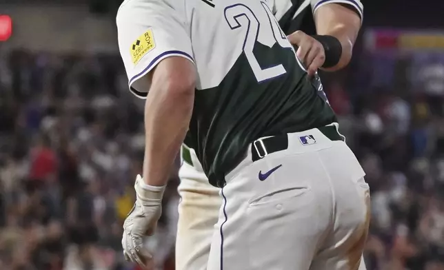 Colorado Rockies' Ryan McMahon, front, and Nolan Jones celebrate the team's win against the Washington Nationals in a baseball game Saturday, June 22, 2024, in Denver. (AP Photo/Geneva Heffernan)