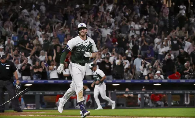 Colorado Rockies' Ryan McMahon tosses his bat after earning a bases-loaded walk to score the winning run against the Washington Nationals in a baseball game Saturday, June 22, 2024, in Denver. (AP Photo/Geneva Heffernan)