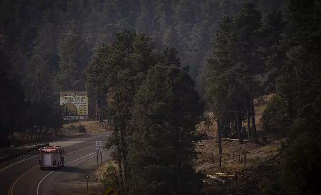 A fire truck drives on New Mexico State Road 48 towards the South Fork Fire near Ruidoso, N.M., on Tuesday, June 18, 2024. The South Fork Fire has consumed nearly 14,000 acres, according to a New Mexico State Forestry Division news release. (Chancey Bush/The Albuquerque Journal via AP)