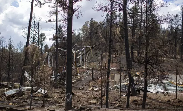 The remains of a house destroyed by the South Fork Fire are pictured in the mountain village of Ruidoso, N.M., Saturday, June 22, 2024. (AP Photo/Andres Leighton)