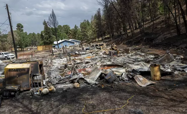 A flattened house that was destroyed by the South Fork Fire is shown in the mountain village of Ruidoso, N.M., Saturday, June 22, 2024. Recent rains and cooler weather are helping more than 1,000 firefighters gain ground on two wildfires in southern New Mexico that have killed two people, destroyed hundreds of homes and forced thousands to flee. (AP Photo/Andres Leighton)