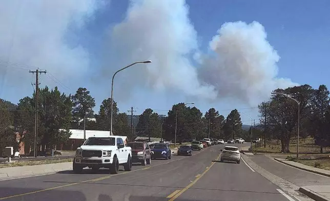 Smoke from a wildfire rises over Ruidoso, N.M., Monday, June 17, 2024. Residents of the mountain village of about 7,000 residents fled their homes under evacuation orders with little time to rescue belongings. (Jacquie Escajeda via AP)