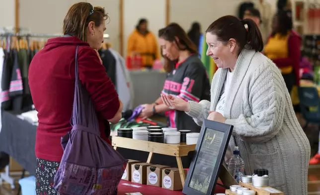 A stall worker talks to a customer during Matariki Whanau Day at the Wainuiomata Community Hub, Wellington, New Zealand on June 22, 2024. Now in its third year as a nationwide public holiday in New Zealand, Matariki marks the lunar new year by the rise of the star cluster known in the Northern Hemisphere as the Pleiades. (AP Photo/Hagen Hopkins)