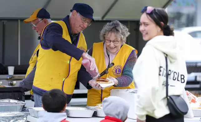 Neil, second left, and Marilyn of the Lions Club of Wainuiomata, work at a barbecue stall during Matariki Whanau Day at the Wainuiomata Community Hub in Wellington, New Zealand on June 22, 2024. Now in its third year as a nationwide public holiday in New Zealand, Matariki marks the lunar new year by the rise of the star cluster known in the Northern Hemisphere as the Pleiades. (AP Photo/Hagen Hopkins)