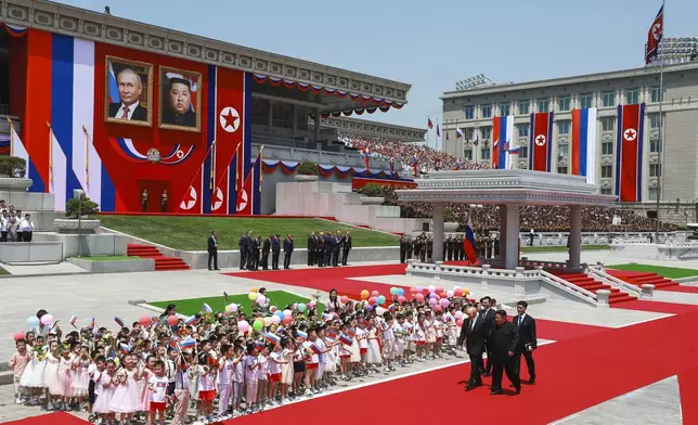 Russian President Vladimir Putin, left, and North Korea's leader Kim Jong Un, foreground right, attend the official welcome ceremony in the Kim Il Sung Square in Pyongyang, North Korea, on Wednesday, June 19, 2024. (Vladimir Smirnov, Sputnik, Kremlin Pool Photo via AP)