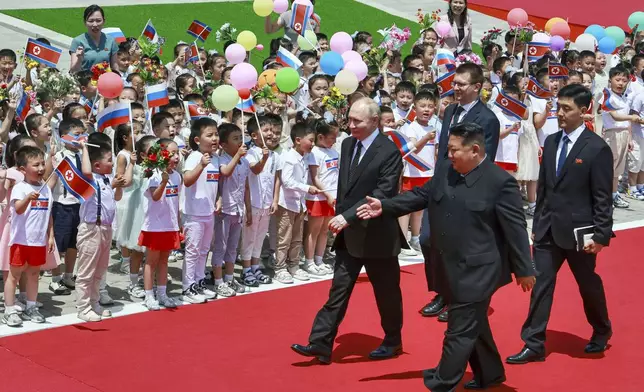 Russian President Vladimir Putin, left, and North Korea's leader Kim Jong Un, foreground right, attend the official welcome ceremony in the Kim Il Sung Square in Pyongyang, North Korea, on Wednesday, June 19, 2024. (Vladimir Smirnov, Sputnik, Kremlin Pool Photo via AP)