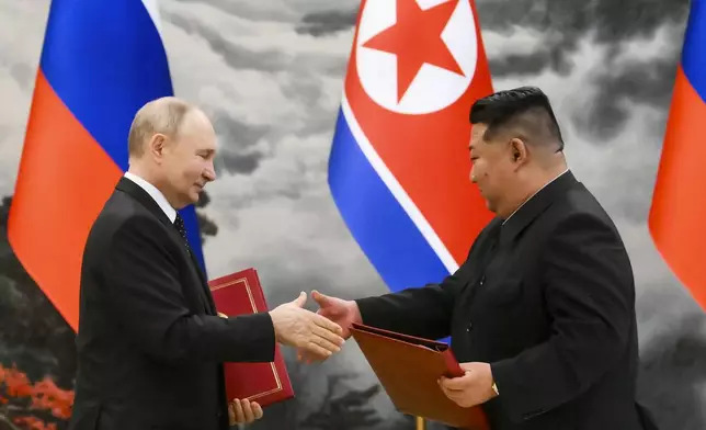 Russian President Vladimir Putin, left, and North Korea's leader Kim Jong Un exchange documents during a signing ceremony of the new partnership in Pyongyang, North Korea, on Wednesday, June 19, 2024. Putin and Kim signed a new partnership that includes a vow of mutual aid if either country is attacked, during a Wednesday summit that came as both face escalating standoffs with the West. (Kristina Kormilitsyna, Sputnik, Kremlin Pool Photo via AP)