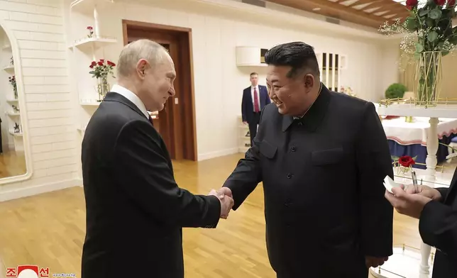 This photo provided Wednesday, June 19, 2024, by the North Korean government, Russian President Vladimir Putin, left, and North Korea's leader Kim Jong Un shake hands at the state guest house in Pyongyang, North Korea, early Wednesday, June 19. The content of this image is as provided and cannot be independently verified. Korean language watermark on image as provided by source reads: "KCNA" which is the abbreviation for Korean Central News Agency. (Korean Central News Agency/Korea News Service via AP)