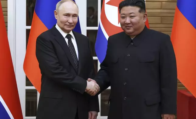 Russian President Vladimir Putin, left, and North Korea's leader Kim Jong Un shake hands while posing for a photo prior to their talks in Pyongyang, North Korea, Wednesday, June 19, 2024. (Gavriil Grigorov, Sputnik, Kremlin Pool Photo via AP)