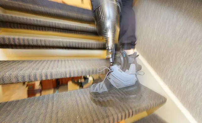 Denver Police Department Sgt. Justin Dodge hurries up the stairs on his prosthetic leg during a training exercise Friday, June 7, 2024, in a former athletic club now vacant in Lone Tree, Colo. Dodge, a SWAT team supervisor who lost his left leg below the knee after being run over by a firetruck during the Denver Nuggets' championship parade last June, is back on the job and makes it his mission to inspire others. (AP Photo/David Zalubowski)