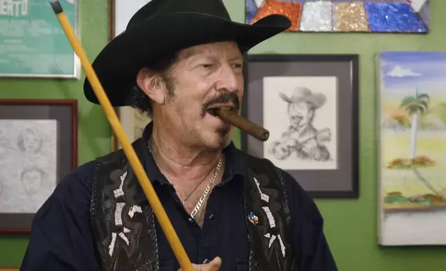 FILE - Texas independent gubernatorial candidate Kinky Friedman is shown at home waiting his turn at the pool table Monday, Nov. 6, 2006, in Austin, Texas. Friedman, the singer, songwriter, satirist and novelist who also dabbled in Texas politics with a campaign for governor, died Thursday at his family’s Texas ranch near San Antonio. He was 79. (AP Photo/Harry Cabluck, File)