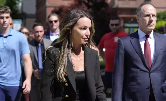 Karen Read, center, arrives at Norfolk Superior Court, while walking near defense attorney David Yannetti, right, Thursday, June 27, 2024, in Dedham, Mass. Read is on trial, accused of killing her boyfriend Boston police Officer John O'Keefe, in 2022. The jury began deliberations in the trial Tuesday. (AP Photo/Steven Senne)