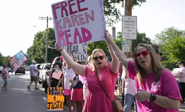 Supporters of Karen Read display signs to passing cars near Norfolk Superior Court, Wednesday, June 26, 2024, in Dedham, Mass. Read is on trial, accused of killing her boyfriend Boston police Officer John O'Keefe, in 2022. The jury began deliberations in the trial Tuesday. (AP Photo/Steven Senne)