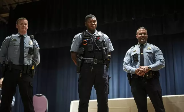 FILE - Officer Jamal Mitchell, center, is presented with a Lifesaving Award by Chief Brian O'Hara, Oct. 4, 2023, during a ceremony in Minneapolis. Body camera footage released Friday, June 21, shows Mitchell’s final moments on May 30, 2024, as he walked into what investigators have called an ambush. (Renée Jones Schneider/Star Tribune via AP, File)