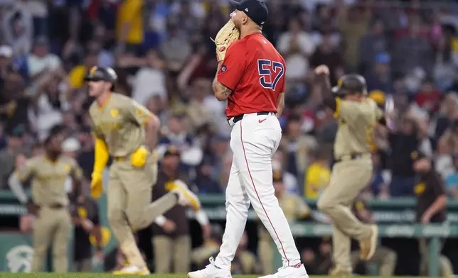 Boston Red Sox relief pitcher Greg Weissert (57) reacts after giving up a three-run home run to San Diego Padres' Jackson Merrill, second from left, during the fifth inning of a baseball game, Friday, June 28. 2024, in Boston. (AP Photo/Michael Dwyer)