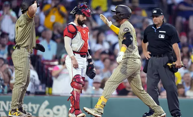 San Diego Padres' Kyle Higashioka right, celebrates his two-run home run that scored Ha-Seong Kim, left, in front of Boston Red Sox catcher Connor Wong during the fifth inning of a baseball game Friday, June 28. 2024, in Boston. (AP Photo/Michael Dwyer)