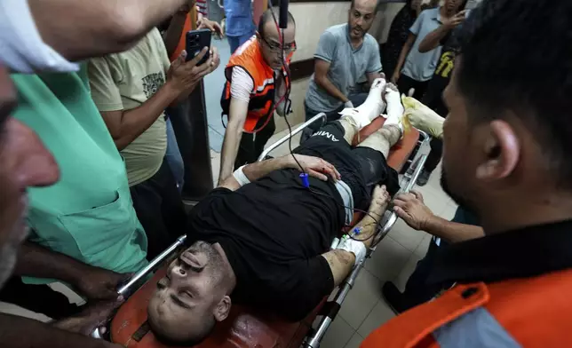 A Palestinian wounded in an Israeli bombardment of Nuseirat refugee camp is brought to al-Aqsa Martyrs Hospital in Deir al Balah, central Gaza Strip, late Thursday, June 27, 2024. (AP Photo/Abdel Kareem Hana)