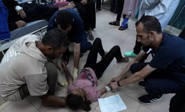 Palestinian medics treat a wounded girl in an Israeli bombardment of Nuseirat refugee camp, at the al-Aqsa Martyrs Hospital in Deir al Balah, central Gaza Strip, late Thursday, June 27, 2024. (AP Photo/Abdel Kareem Hana)