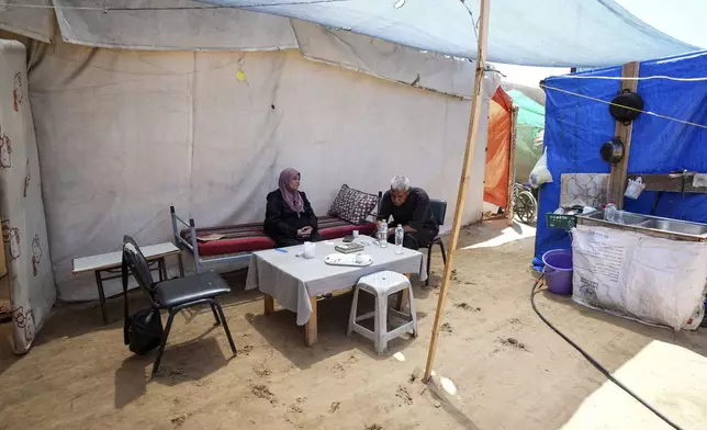 Ibrahim Abu Shaaban sits with his wife in their tent on Thursday, June 13, 2024 in Deir al Balah, Gaza Strip. The couple had planned to perform the Hajj pilgrimage this year, but like all Palestinians in the coastal enclave of Gaza were not able to travel to Mecca because of the closure of the Rafah crossing in May when Israel extended its ground offensive to the strip's southern city of Rafah on the border with Egypt. (AP Photo/Abdel Kareem Hana)