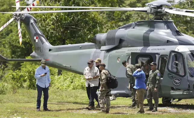 Panamanian President-elect Jose Raul Mulino, second from left, exits a helicopter at a camp where migrants stop temporarily for food and shelter after walking across the Darien Gap from Colombia, in Lajas Blancas, Panama, Friday, June 28, 2024. (AP Photo/Matias Delacroix)