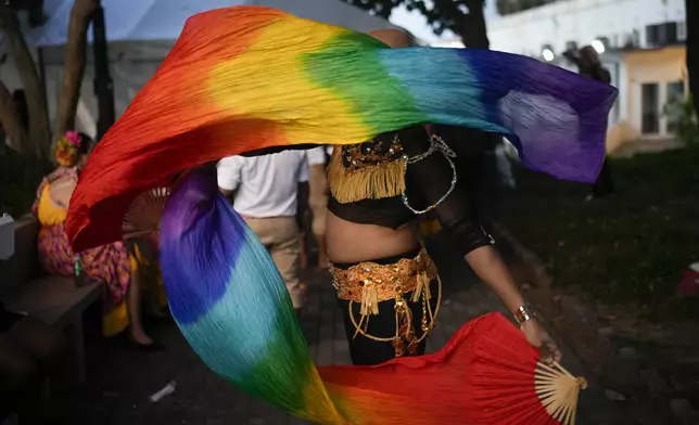A reveler waves a rainbow-colored scarf during a Gay Pride parade marking the culmination of LGBTQ+ Pride month, in Panama City, Saturday, June 29, 2024. (AP Photo/Matias Delacroix)
