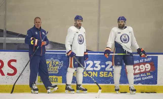 Edmonton Oilers' defensive coach Paul Coffey stands with Connor McDavid (97) and Leon Draisaitl (29) during practice in Edmonton on Thursday June 20, 2024. The Edmonton Oilers take on the Florida Panthers in game 6 of the NHL Stanley Cup final on Friday. Jason Franson/The Canadian Press via AP)
