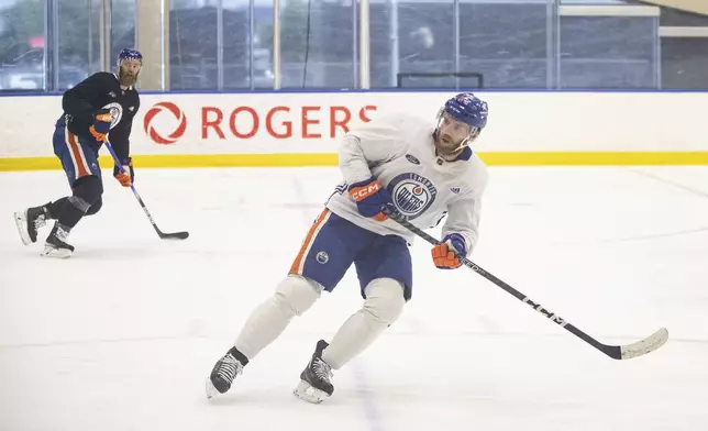 Edmonton Oilers' Connor McDavid (97) and Mattias Ekholm (14) skate a drill during practice in Edmonton on Thursday June 20, 2024. The Edmonton Oilers take on the Florida Panthers in game 6 of the NHL Stanley Cup final on Friday. Jason Franson /The Canadian Press via AP)