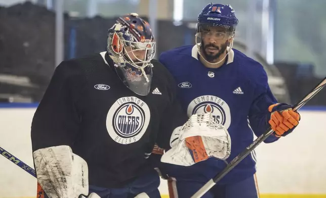 Edmonton Oilers goalie Stuart Skinner (74) and Evander Kane (91) chat during practice in Edmonton on Thursday June 20, 2024. The Edmonton Oilers take on the Florida Panthers in game 6 of the NHL Stanley Cup final on Friday. Jason Franson /The Canadian Press via AP)