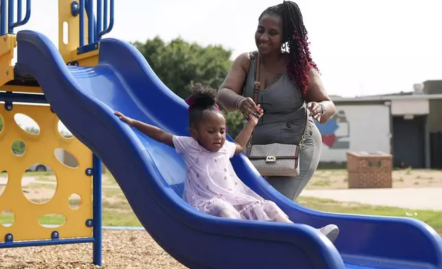 Tamika Davis, right, spends time with her daughter, Shanara, 3, at MLK Park in San Antonio, Thursday, May 30, 2024. Davis said friends and family watched her kids for most of her doctor visits during treatment last year for colon cancer. But she couldn't afford additional childcare, and she didn't know where to look for assistance. (AP Photo/Eric Gay)