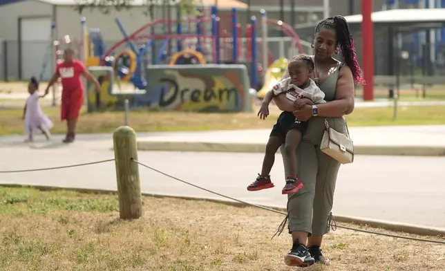 Tamika Davis, right, poses with three of her children, from left, Shanara, 3, Matthew, 11, and Lionel Jr., 2, at MLK Park in San Antonio, Thursday, May 30, 2024. Davis said friends and family watched her kids for most of her doctor visits during treatment last year for colon cancer. But she couldn't afford additional childcare, and she didn't know where to look for assistance. (AP Photo/Eric Gay)